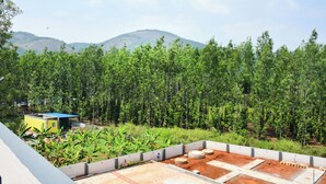 Une terrasse sur le toit offrant une vue sur une forêt et des collines.