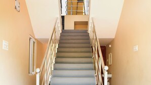 Un escalier avec des rampes en métal et un motif de carreaux sur le sol.