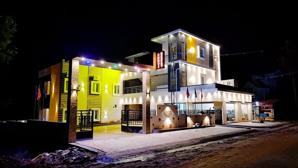 Un hôtel à plusieurs étages, doté d’une façade jaune vif, de nombreux balcons et d’une entrée bien éclairée.
