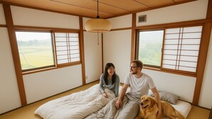 A traditional Japanese-style room with tatami flooring, a low bed, and shoji screens. - Guesthouse & Sharehouse carima azumik (Omachi)