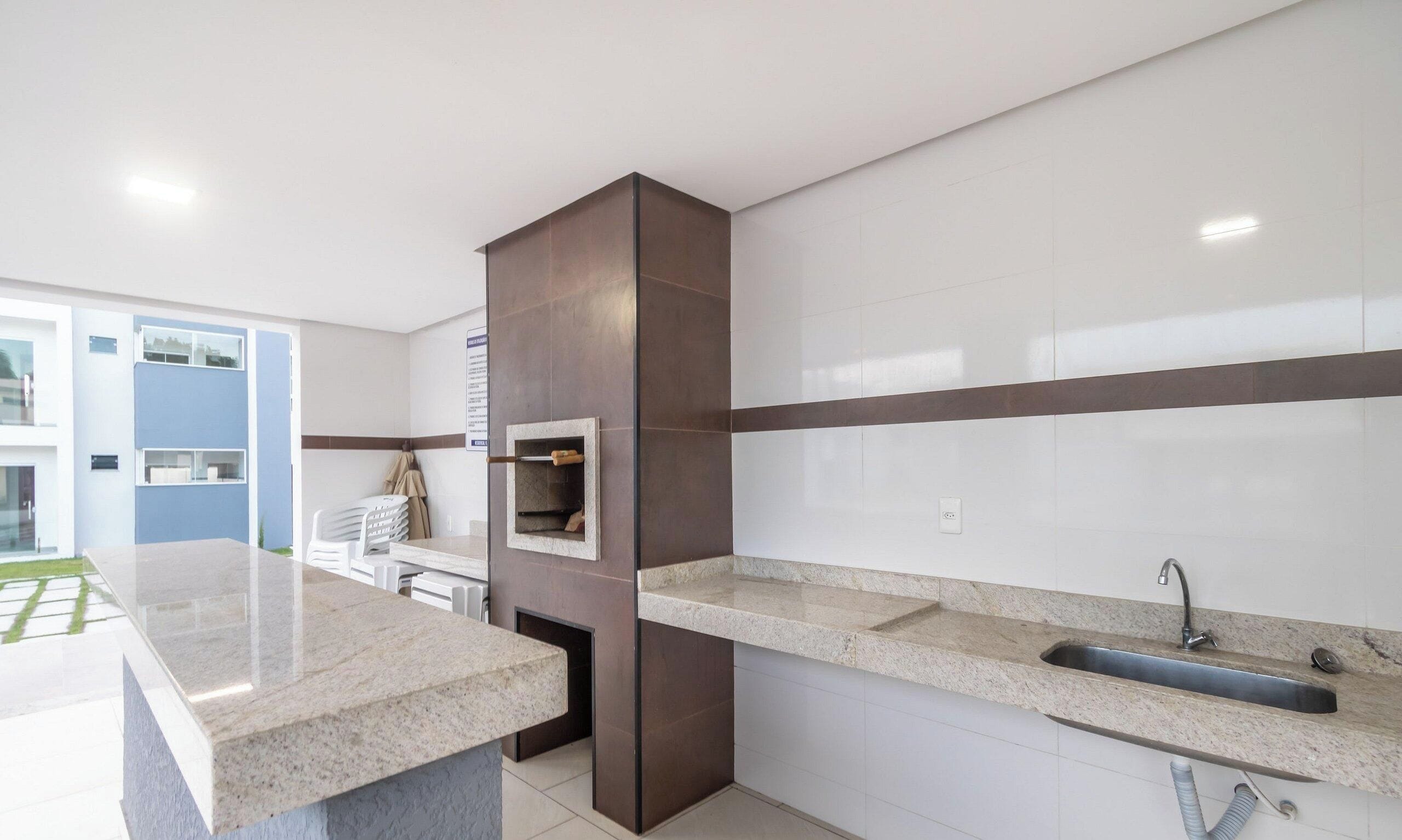 Una cocina moderna con una isla central, horno empotrado y un lavamanos con grifo.