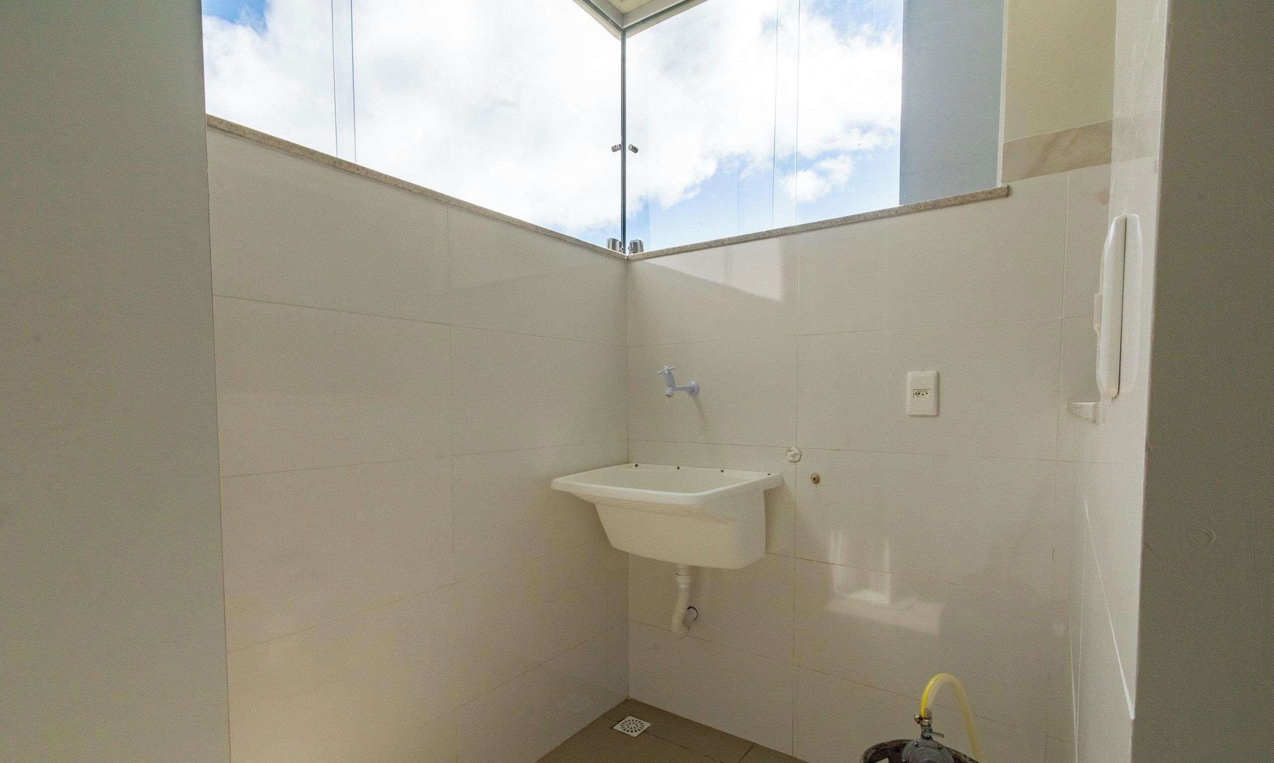 Une petite salle de bain propre, avec un seul lavabo, un miroir et une douche.