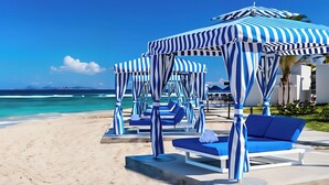 Een strandresort met gestreepte parasols en ligstoelen.