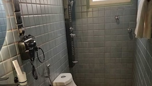 Een kleine badkamer met toilet, wastafel en een raam.