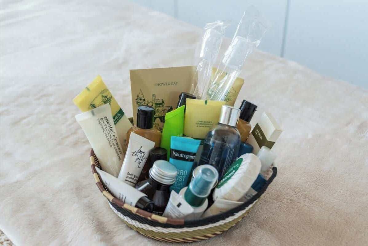 A basket filled with various toiletries and a shower cap.