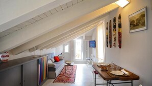 A modern loft apartment with a dining area, a sofa, and a kitchen. - Willy's Home (Salerno)