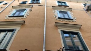 A building facade with multiple windows, a central vertical pipe, and a street lamp. - Willy's Home (Salerno)
