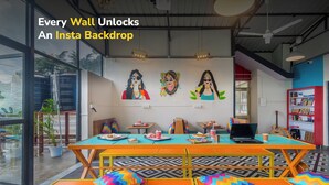 A vibrant indoor space with colorful seating, a laptop on a table, and a bookshelf. - goSTOPS Mcleodganj, Mall Road (McLeod Ganj)