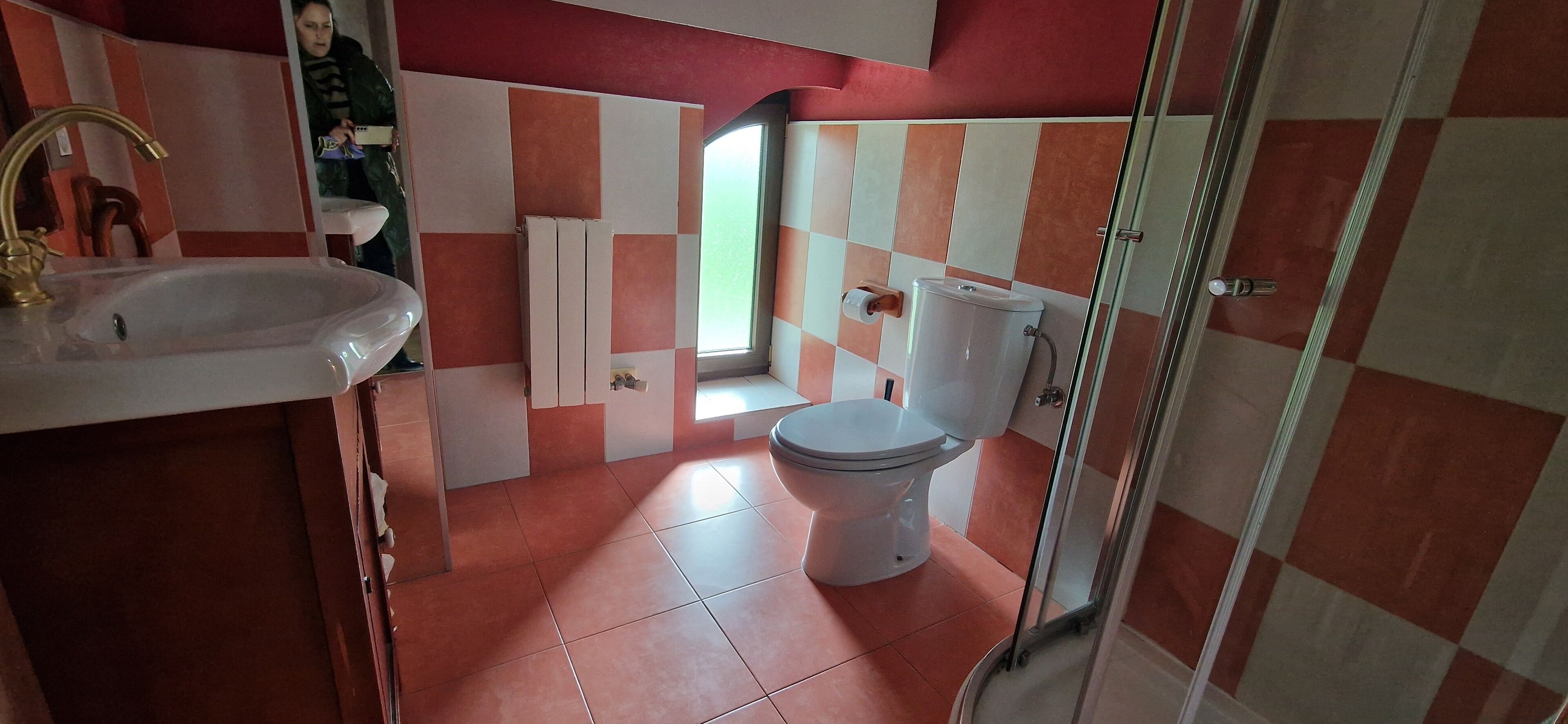 Casa de banho com lavatório, sanita e chuveiro.
