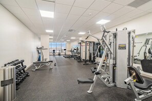 A gym with various exercise equipment, including dumbbells, treadmills, and weight machines.