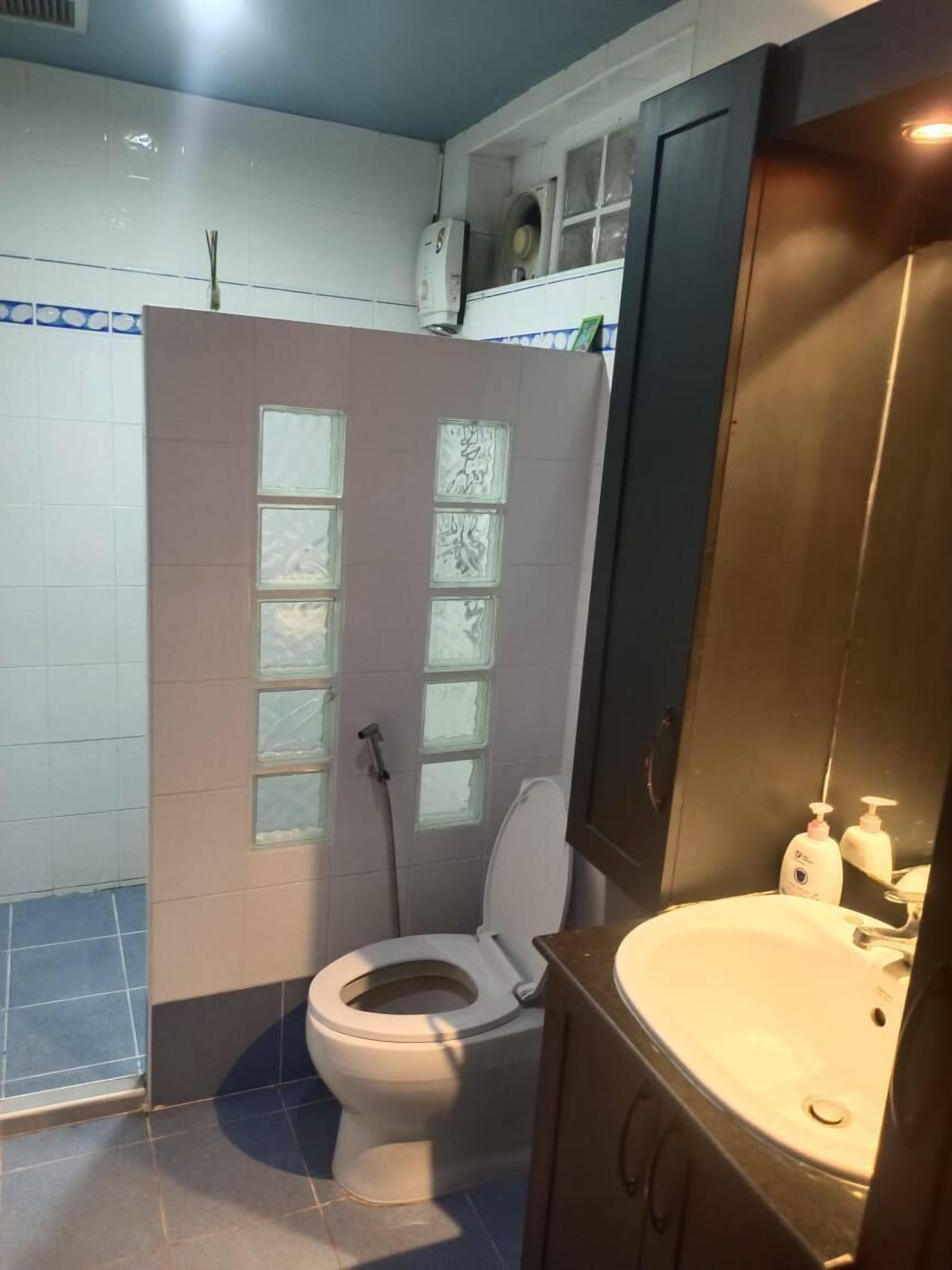 A bathroom with a toilet, a sink, and a shower area.