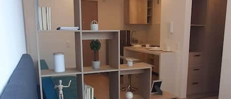 Relax in a spacious bedroom with a large bed and shelving unit, perfect for reading and relaxation.