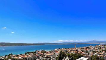 A coastal town with buildings, a clear blue sky, and a view of the sea.