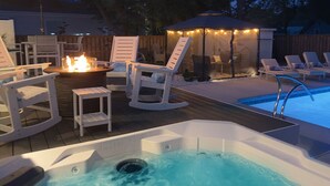 Ein Whirlpool, Liegestühle und ein Poolbereich mit Lichterketten.