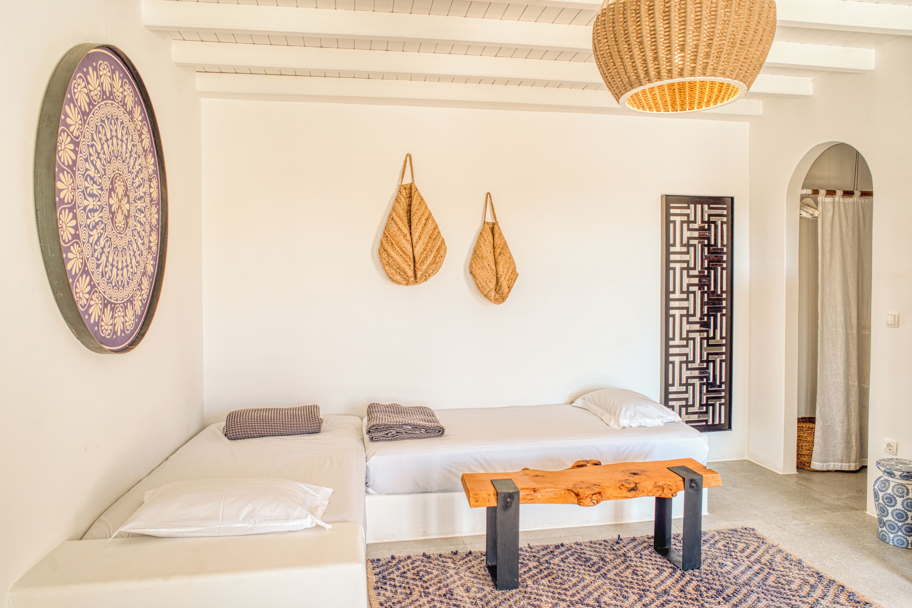 Une chambre à coucher comprenant un lit, un banc, une décoration murale et un motif décoratif sur le mur.