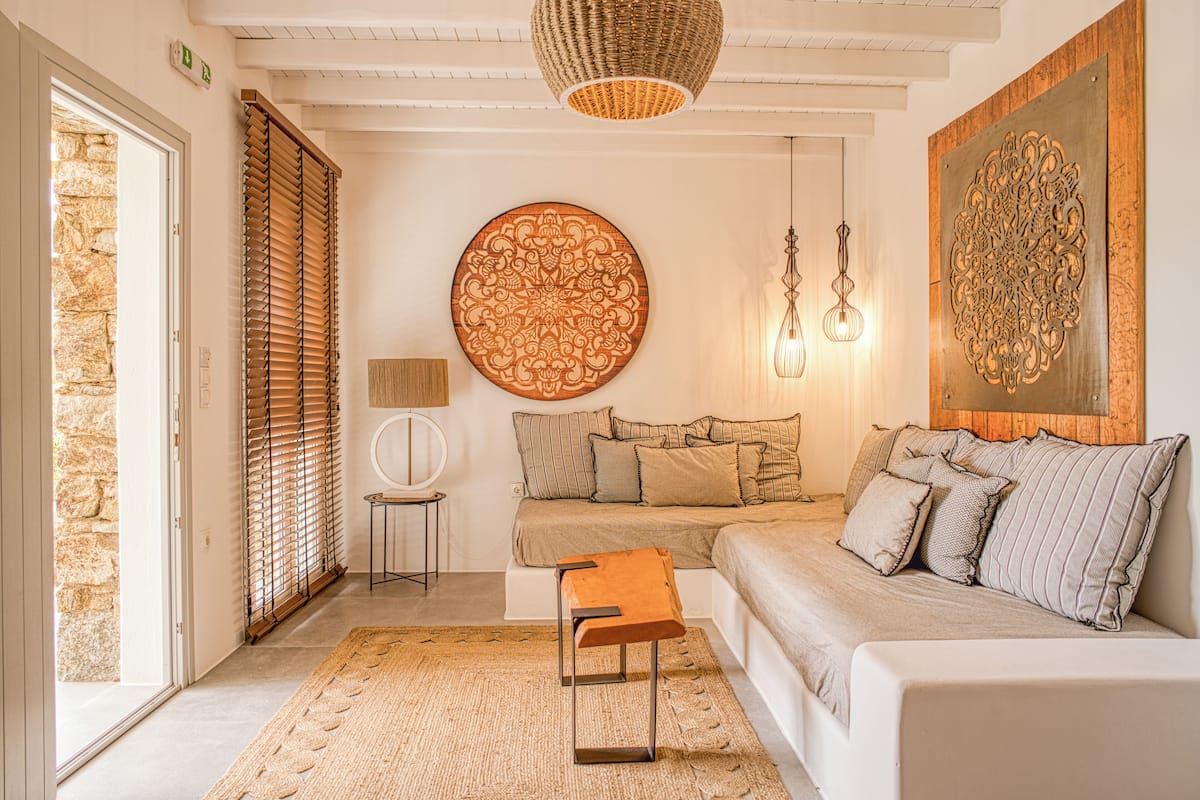 A modern living room with a sofa, a coffee table, and a large decorative wall piece.