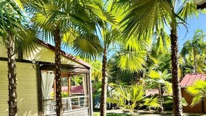 Ein kleines, eingeschossiges Gebäude mit Veranda und einem Fenster mit Vorhängen.
