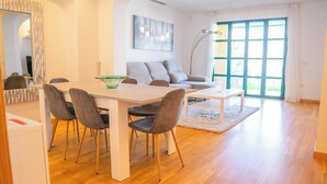 A modern living room with a dining table, chairs, a sofa, and a coffee table. - Villa Luisa: Relax with ocean view and swimming pool (Los Abrigos)