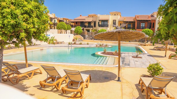 A pool area with lounge chairs and a thatched umbrella. - Villa Luisa: Relax with ocean view and swimming pool (Los Abrigos)