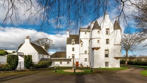 Un grand bâtiment blanc, ressemblant à un château, doté de nombreuses tours et d’une entrée centrale.