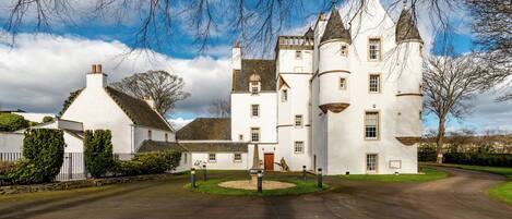 A large, white, castle-like building with multiple towers and a central entrance.
