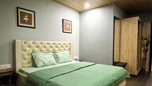 Ein Schlafzimmer mit einem großen Bett, einer Holzbalkendecke und zwei gerahmten Bildern an der Wand.