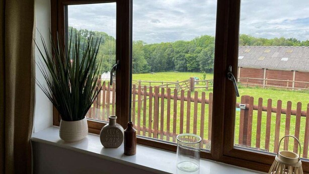 A room with a large window overlooking a fenced yard.