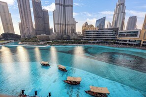 A waterfront area with boats and a city skyline in the background. - Durrani Homes - Heaven on Earth collection 5BR with panorama Burj Khalifa and fountain views (Dubai)