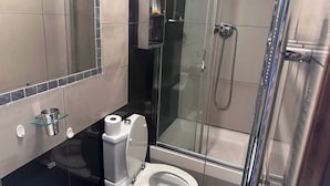 A modern bathroom with a glass-enclosed shower, a toilet with a glass shelf, and a mirror. - 3b-10min City Airport, Parking, No Parties Allowed (London)