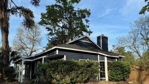 A two-story house with a gabled roof, a chimney, and a covered porch.