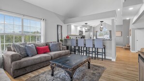 A spacious living area with a sofa, coffee table, and a kitchen in the background. - 3 King Suites near Silver Dollar City & the Strip (Branson)
