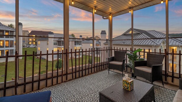 A covered outdoor seating area with a view of residential buildings, a ceiling fan, and string lights. - 3 King Suites near Silver Dollar City & the Strip (Branson)
