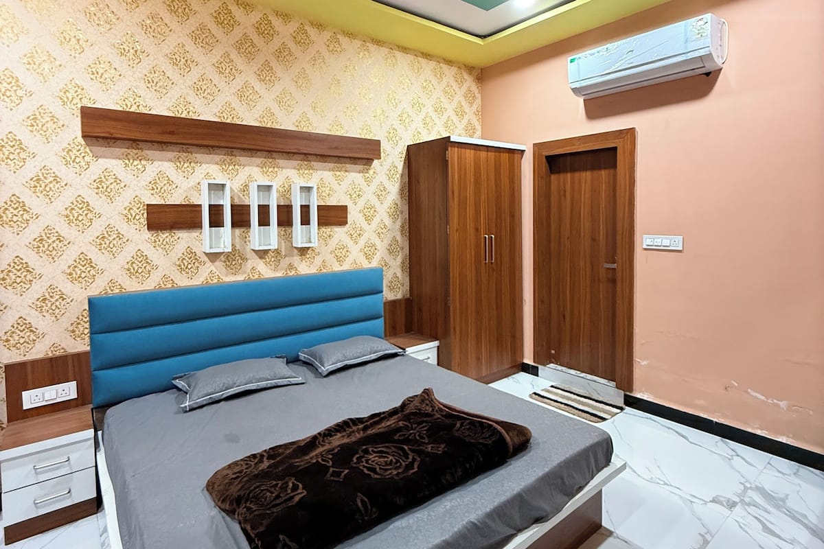Une chambre à coucher comprenant un lit, une armoire et un appareil de climatisation.