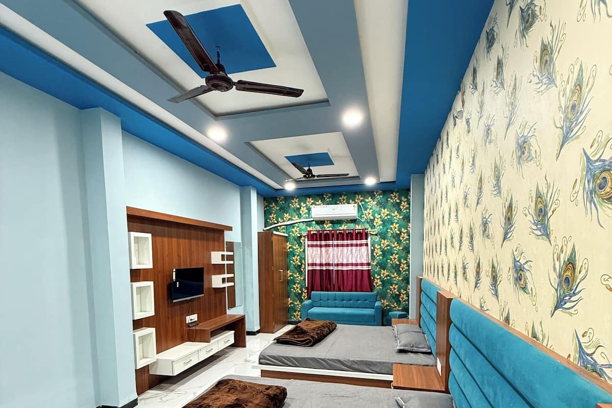 Une chambre avec un grand lit, une télévision et un ventilateur de plafond.