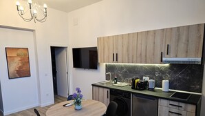 A modern kitchen with wooden cabinets, a built-in oven, and a flat-screen TV. - Inspiracion Valencia (València)