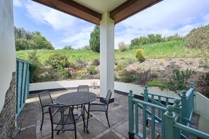 Enjoy dining or socializing in this outdoor space overlooking a lush garden.