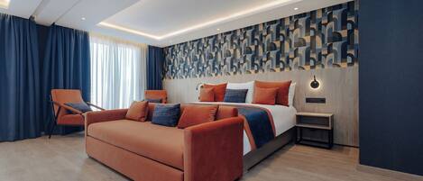 A modern bedroom with a large bed, a sofa, and a nightstand.