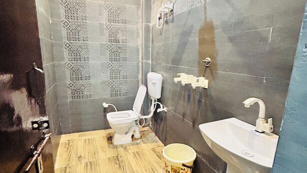 Un baño con inodoro, lavabo y azulejos estampados.
