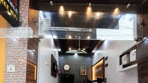 A reception area with a marble counter, a clock, and a framed picture on the wall. - AGRAWAL INN Guest House  (Mathura)