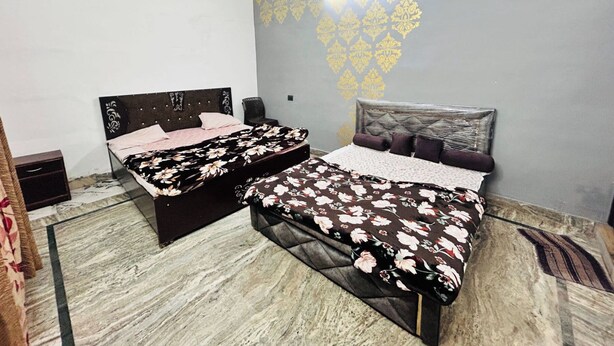 Un dormitorio con dos camas, ventilador de techo y pared con diseño.