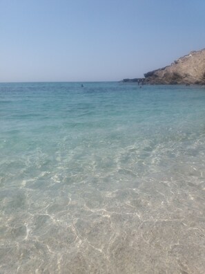 A clear view of a beach with shallow water and a rocky cliff. - Villa in Sardinia, 5 minutes from the beach   (Porto Torres)