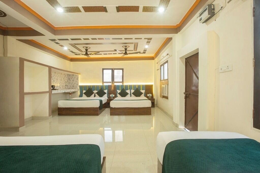 A hotel room with two beds, a ceiling fan, a window, and a door.