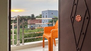 Un balcon donnant sur un immeuble et un ciel dégagé.