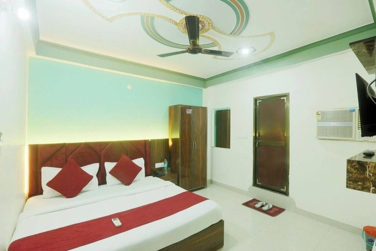 A hotel room with a bed, wardrobe, TV, and a ceiling fan.