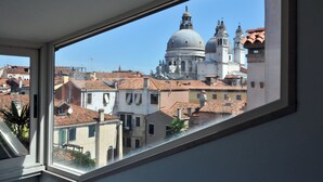 A view from a window overlooking a cityscape with historic buildings and a prominent dome structure.