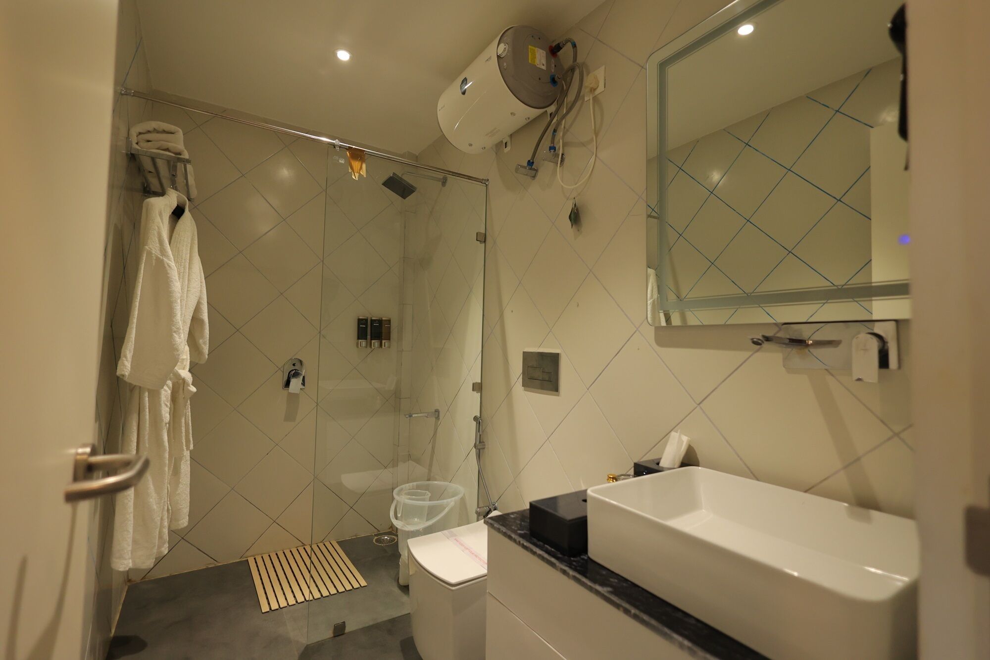 A modern bathroom with a glass shower enclosure, a white sink, and a large mirror.