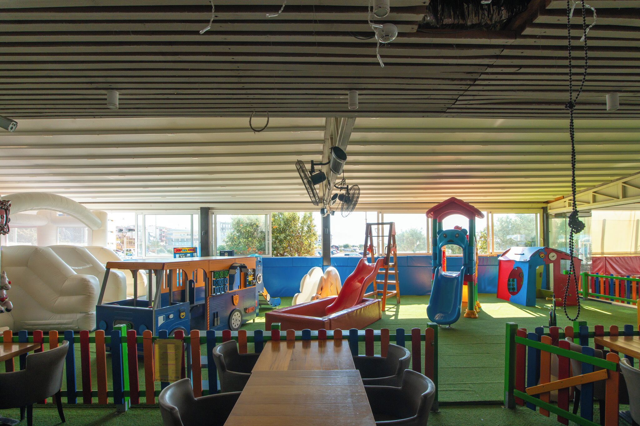 A children's play area with a slide, play structures, and a table with chairs.