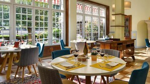 A restaurant with round tables, blue chairs, and a checkered floor. - Domaine des Chateaux (Chaumont-sur-Loire)