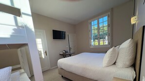 A bedroom with a bed, a television, a window, and a desk. - Domaine des Chateaux (Chaumont-sur-Loire)