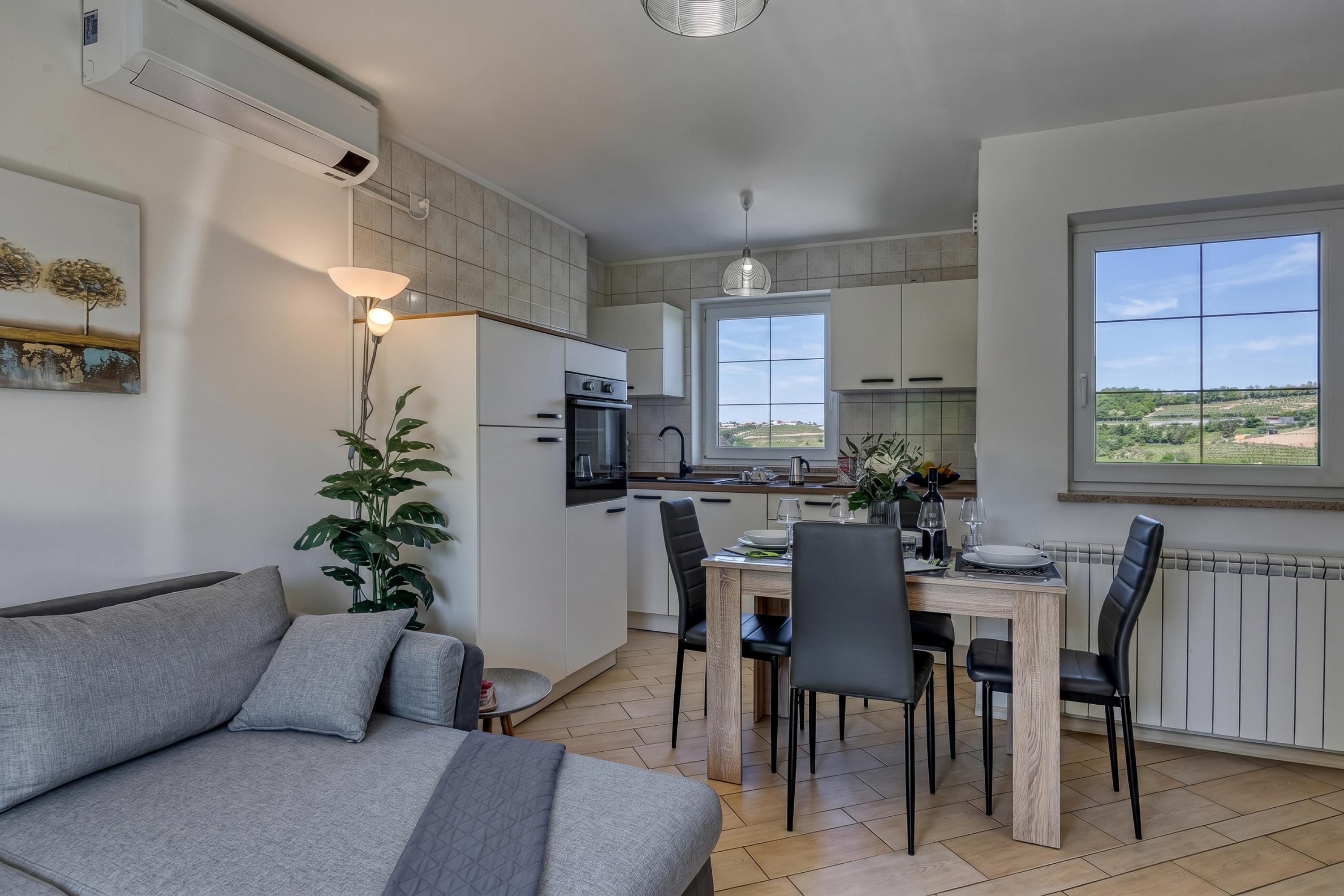 Una cocina moderna con comedor, sofá y vistas al campo.